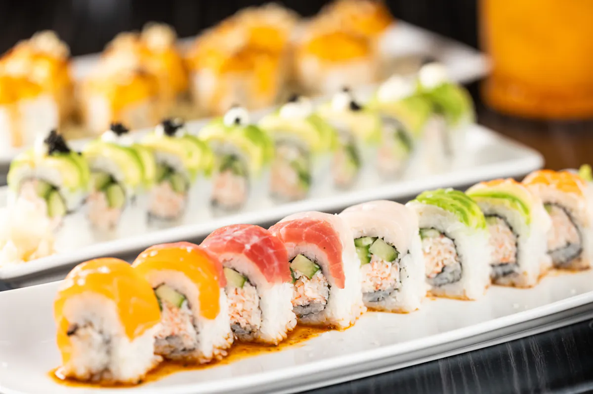 a row of sushi rolls on a white plate